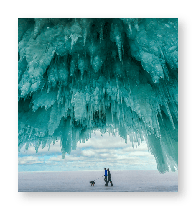 A cave with a ceiling full of turquoise colored Stalactites.